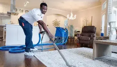 Technician pulling water out of a living room rug with an extraction wand