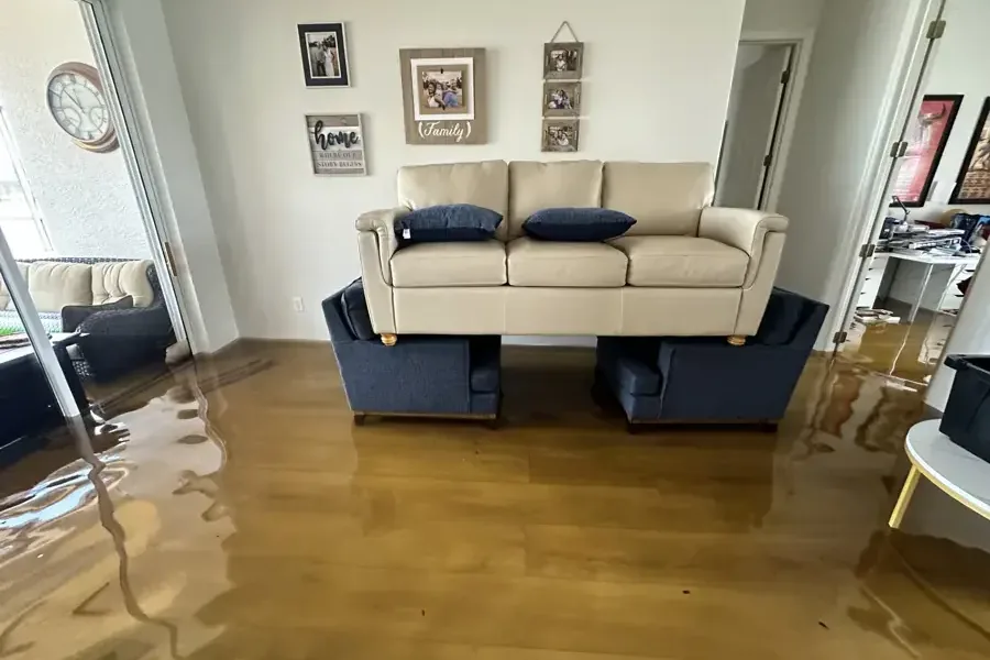Storm floodwater spread across the living room floor of a home