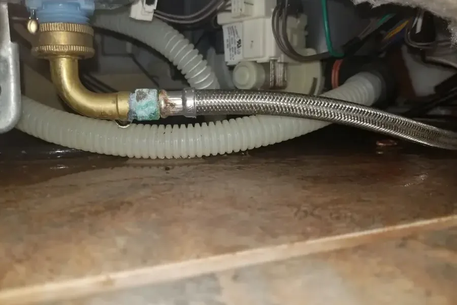 Leak at a braided supply hose and brass fitting under a dishwasher